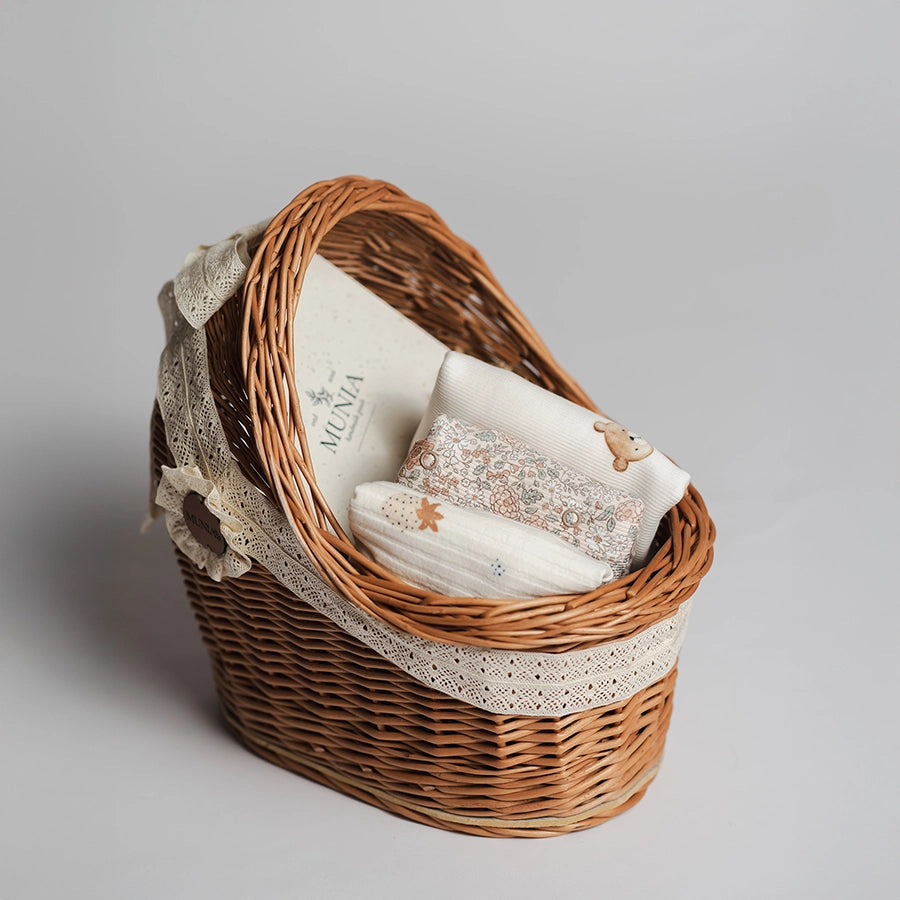 koszyczek prezentowy na baby shower z ubrankami niemowlęcymi w stylu boho - body z krótkim i długim rękawem oraz bawełniana czapeczka.