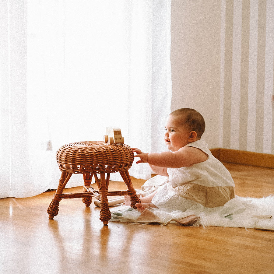 Wiklinowy stołek dla dzieci w wybielanym kolorze, elegancki i lekki, idealny do pokoju dziecięcego lub stylu boho.