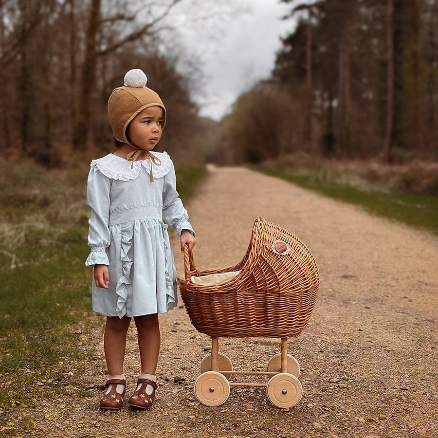 Tall wicker doll pram in natural color with berry bedding